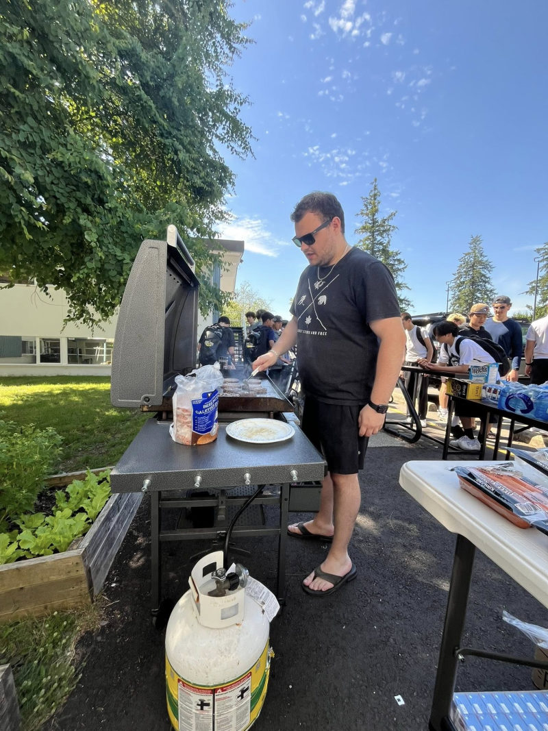 Tali Campbell grilling burgers at an outdoor barbecue.