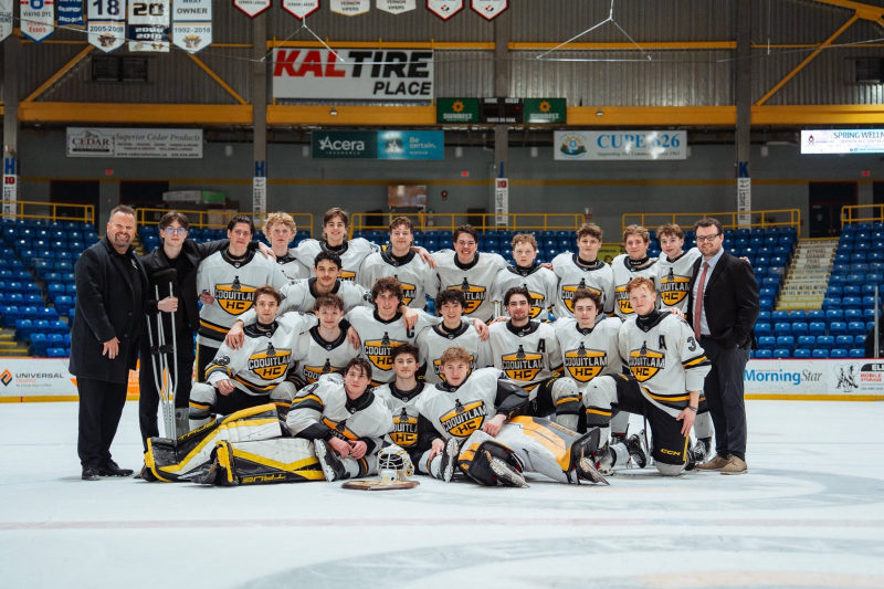 Full Coquitlam HC team photo on the ice with staff on either side.
