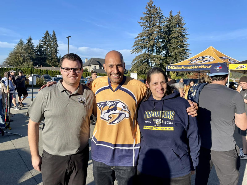 Tali Campbell at an outdoor event with team apparel and tent.