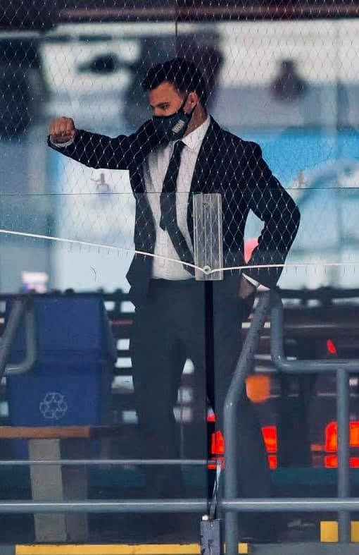 Tali Campbell in a suit and face mask leaning on the rink glass at the arena.